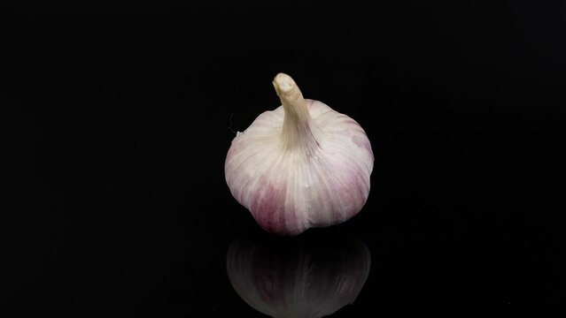 spining garlic on the black background, garlic on the black , close-up of garlic, garlic rotating on a black  background