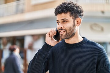 Young arab man smiling confident talking on the smartphone at street