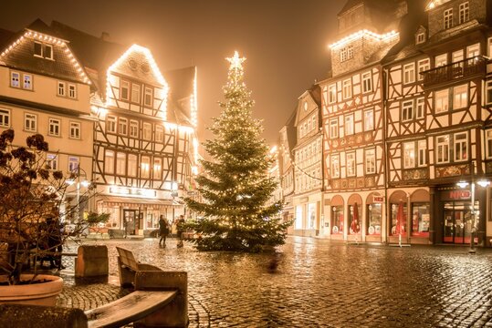 Cozy buildings of Butzbach, Germany surrounding the Christmas tree with the lights on at nighttime