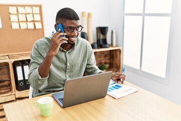 Young african american man talking on the smartphone working at office