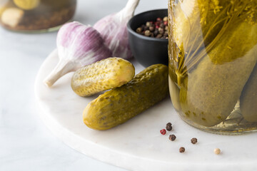 Close up of homemade dill pickles surrounded by ingredients.