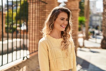 Fototapeta premium Young woman smiling confident looking to the side at street