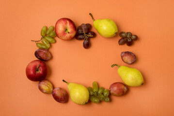 Fruits Apple Plums Pears on Orange Background in Shape of Wreath Top View Horizontal