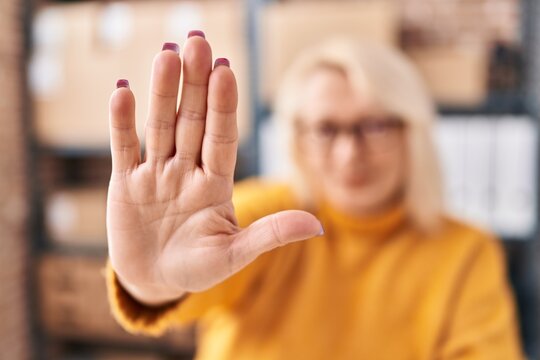 Middle Age Blonde Woman Ecommerce Business Worker Doing Stop Gesture With Hands At Office