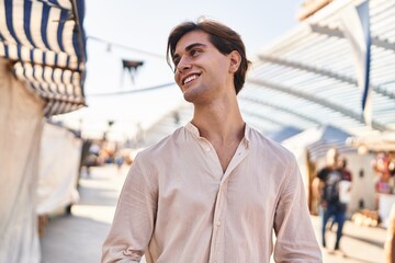 Young caucasian man smiling confident looking to the side at street