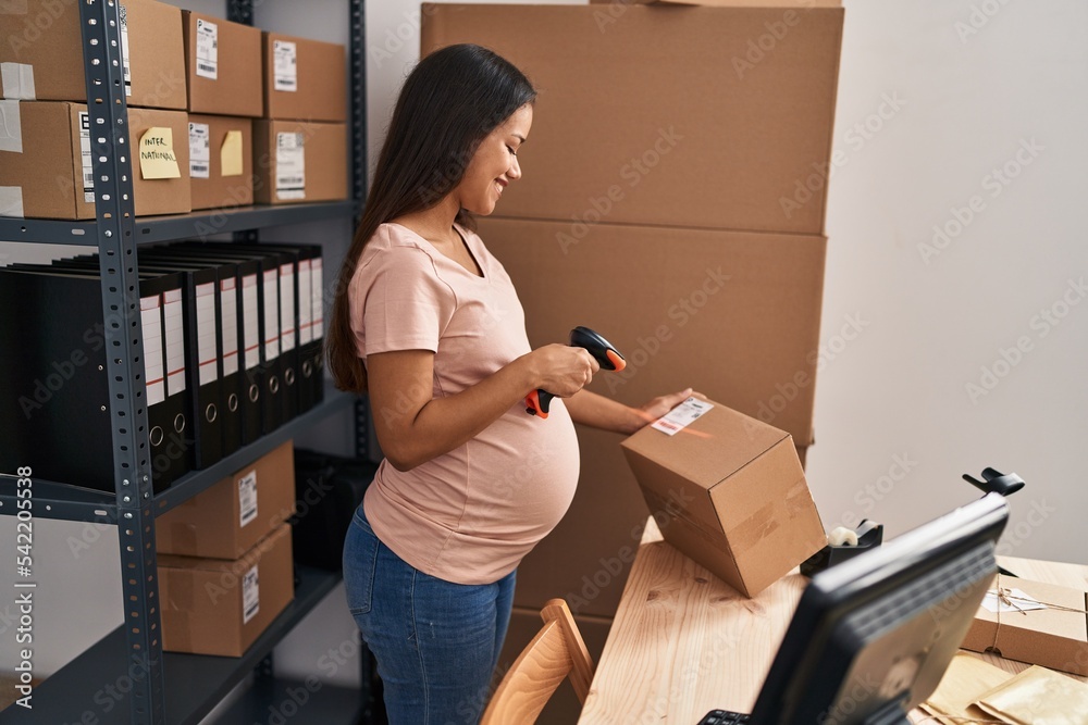 Poster young latin woman pregnant business worker scanning package label at office