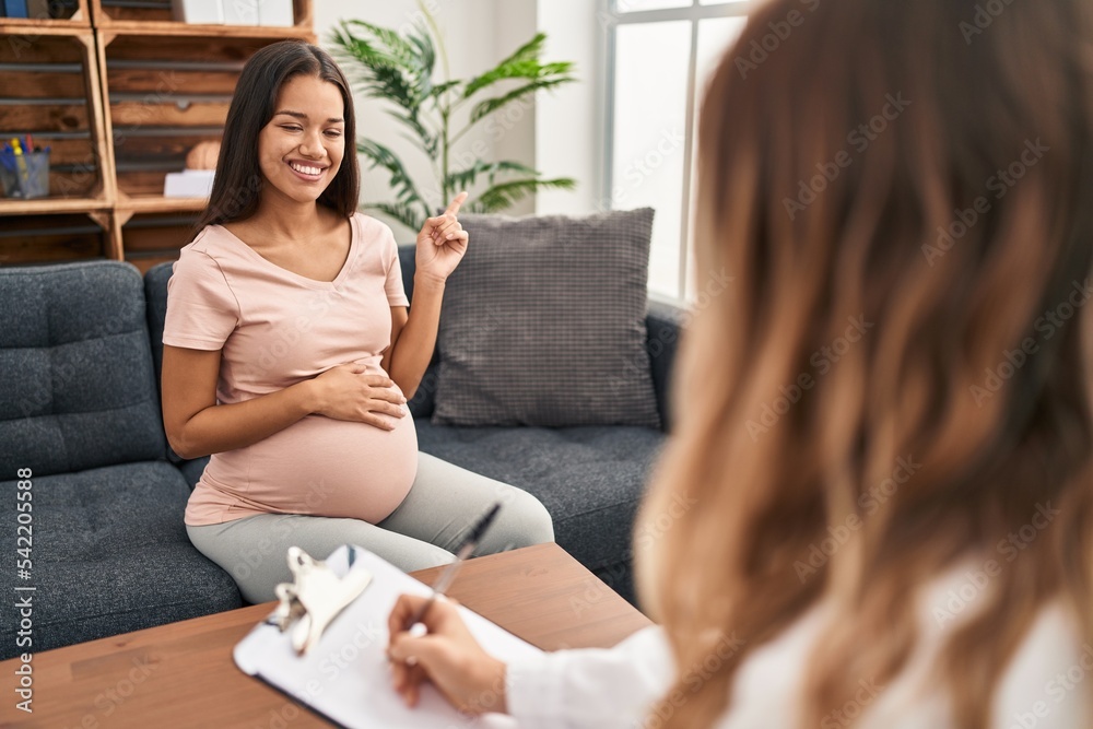 Sticker Young pregnant woman at therapy session smiling happy pointing with hand and finger to the side