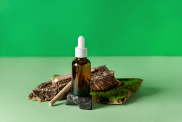Serum Glass Bottle Green Background Composition with Natural Materials: Tree Bark, Stones Wooden Sticks Health and Natural Care Cosmetics Concept