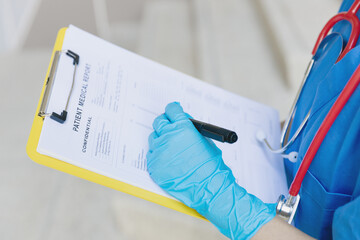 Doctor nurse writing followup information in medical examination document for patient health check in hospital or clinic.