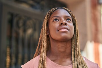 African american woman looking to the sky with serious expression at street