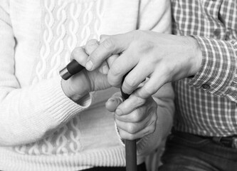 Fototapeta premium Helping hands, care for the elderly concept. Close-up handshake. Black and white photo.