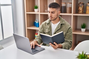 Young hispanic man sitting on table studying at home