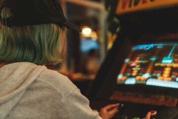 Teenage girl is playing arcade video game.