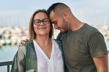 Obraz premium Man and woman mother and daugther hugging each other at seaside