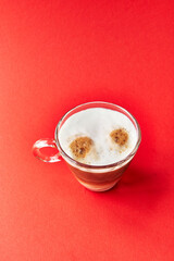  One cup of cappuccino coffee over red background