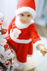 Merry bright christmas. Lovely baby enjoy christmas. Childhood memories. Santa girl little child celebrate christmas at home. Family holiday. Girl cute child cheerful mood play near christmas tree.