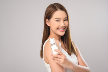 Portrait of beautiful asian woman holding moisturizer cream over white background studio, skin care and beauty concept