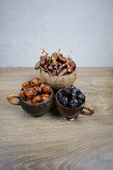 Three types of dates inside wooden cup each
