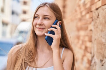 Young caucasian woman smiling confident talking on the smartphone at street