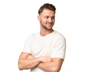 Young blonde caucasian man over isolated background with arms crossed and happy