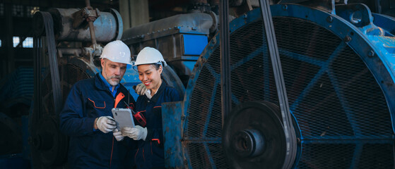 Team engineers are on duty and talking, looking at, and repairing the big machine in the railroad garage.