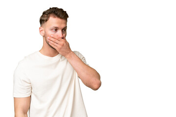 Young blonde caucasian man over isolated background doing surprise gesture while looking to the side