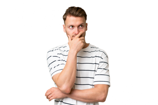Young blonde caucasian man over isolated background having doubts and with confuse face expression