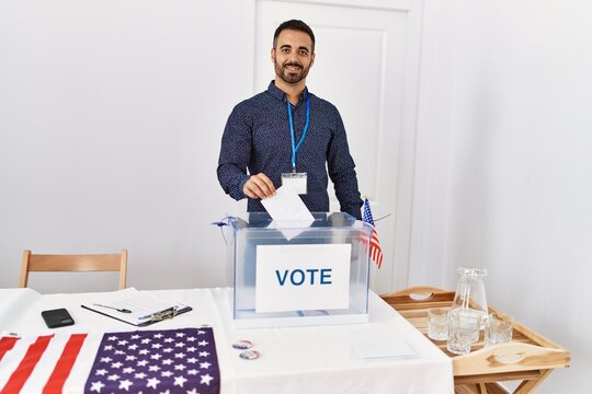 Young hispanic man smiling confident voting at electoral college
