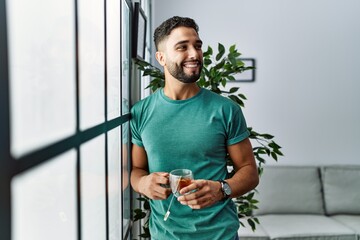 Young arab man smiling confident drinking tea at home