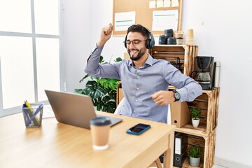 Young arab man smiling confident listening to music at office