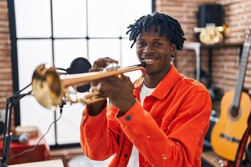 African american man musician playing trumpet at music studio