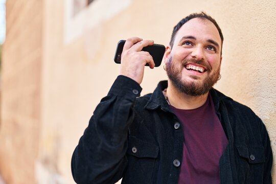 Young hispanic man smiling confident listening audio message by the smartphone at street