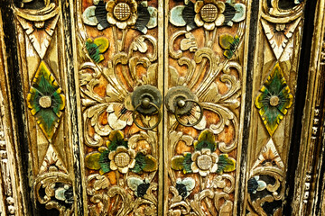 Bali style green wooden carved door in the traditional house of Ubud, Bali, Indonesia