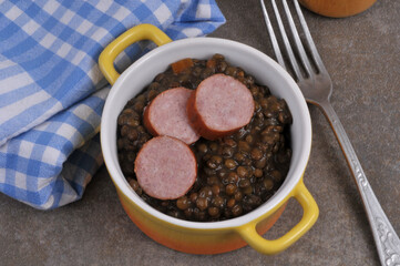 Cocotte de lentilles et saucisse avec une fourchette en gros plan
