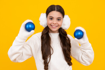 Fototapeta premium Merry christmas and happy New year. Kid in winter clothes. Teen girl with decorative christmas ball. Happy face, positive and smiling emotions of teenager girl.