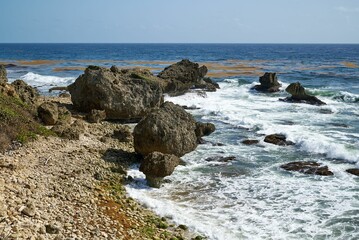 Seascape view with large stones on the foamy beach