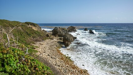 Seascape view with large stones on the foamy beach