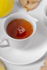 A cup of fresh tea with lemon and ginger. White background, isolated white. Close up.