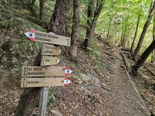 Wooden direction sign for hikers on the Eppan mountain trail in South Tyrol, Italy.