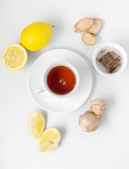 A cup of fresh tea with lemon and ginger. White background, isolated white. Top view. Copy space.