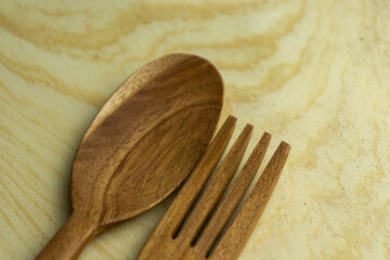 close up of wooden spoon and fork on wooden plate