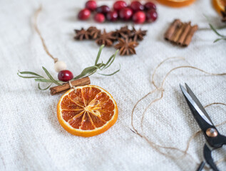 Natürliche Dekoration für Weihnachten mit getrockneten Orangenscheiben, Zimt, Cranberry, Anis und Eukalyptus, Weihnachtsdeko im Scandi-Look minimalistisch gestaltet
