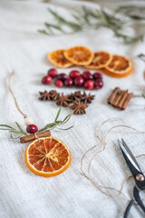 Natürliche Dekoration für Weihnachten mit getrockneten Orangenscheiben, Zimt, Cranberry, Anis und Eukalyptus, Weihnachtsdeko im Scandi-Look minimalistisch gestaltet
