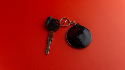 Black motorcycle key with black round keychain on red background. keychain mockup for design