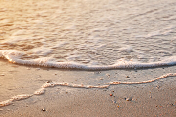 Fototapeta na wymiar beautiful golden sand beach sunrise fresh sea breeze summer vacation. bubble sea water wave