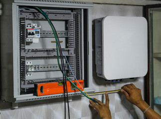 electric man install inverter panel for solar cell on wall house technician maintenance wire...