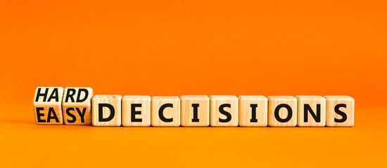 Hard or easy decisions symbol. Concept words Hard decisions and Easy decisions on wooden cubes. Beautiful orange table orange background. Business hard or easy decisions concept. Copy space.