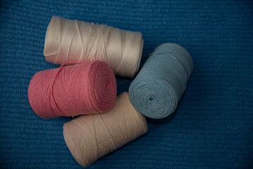 Macrome threads of white,blue,pink,beige on a blue surface