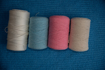 Macrome threads of white,blue,pink,beige on a blue surface