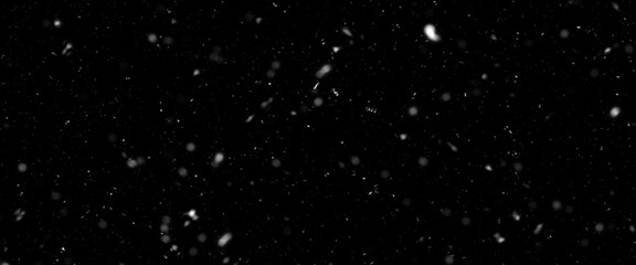 Falling snow isolated on black background. Falling snow at night. Bokeh lights on black background, flying snowflakes in the air. Winter weather. Overlay texture.	